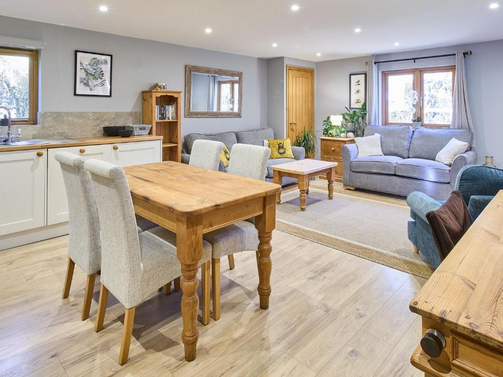 a kitchen and living room with a wooden table and chairs at Host & Stay - Orchard Barn in Ashford