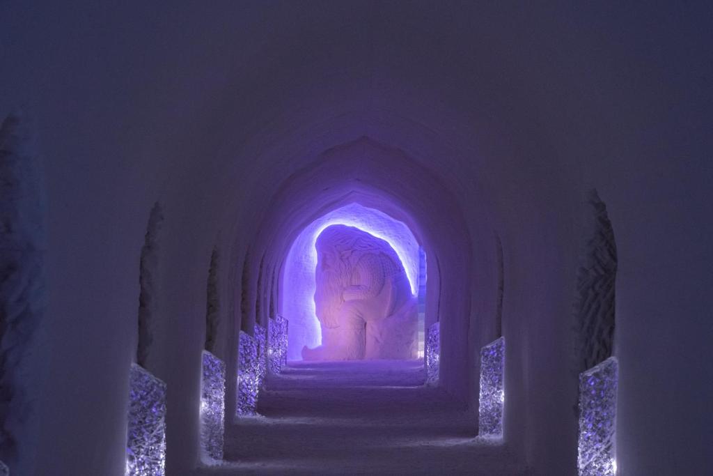 a statue of a woman in an archway with purple lights at Sorrisniva Igloo Hotel in Alta
