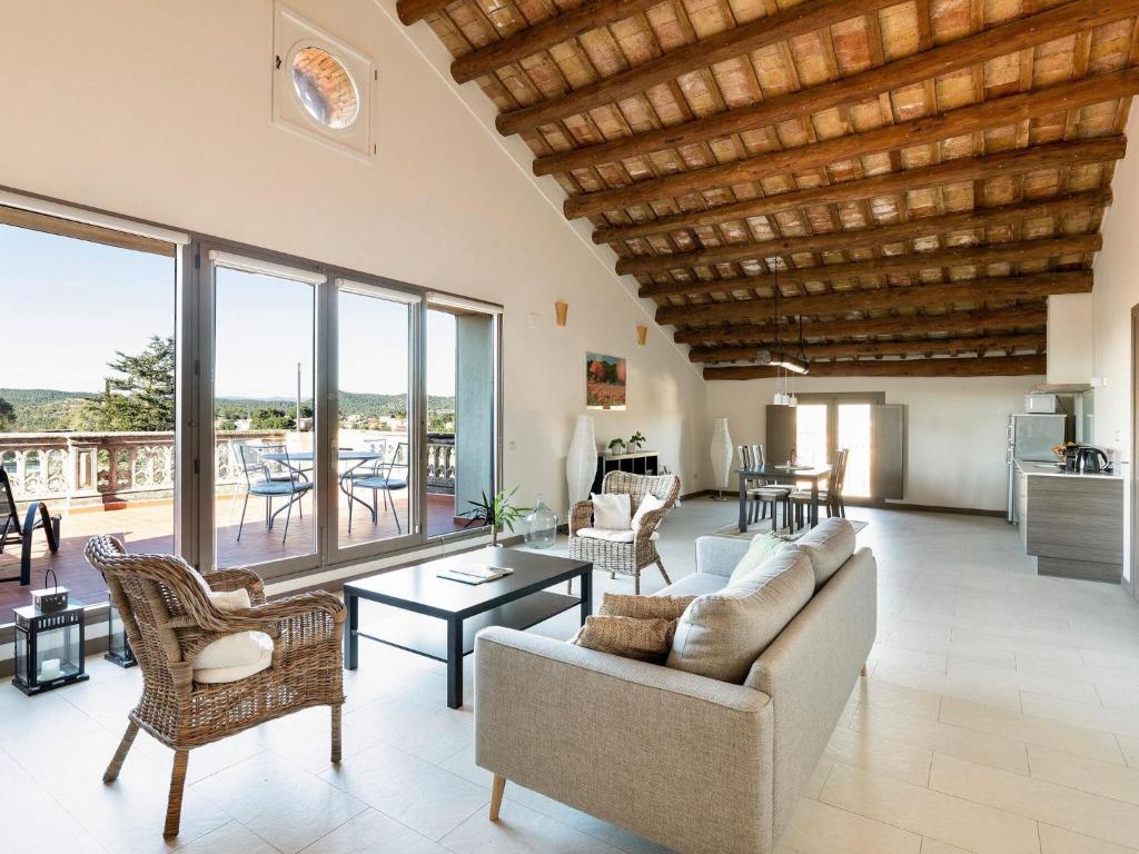 ein Wohnzimmer mit einem Sofa und Stühlen in der Unterkunft Montserrat apartment with terrace and pool in La Torre de Claramunt