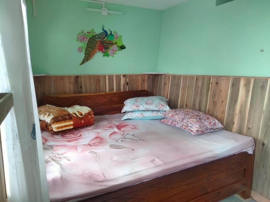 a bed with pink sheets and pillows on it at Diksha Homestay in Darjeeling