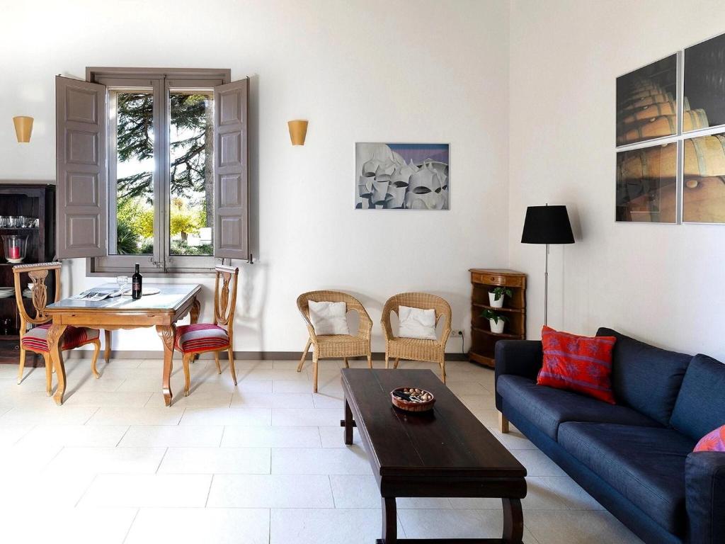 ein Wohnzimmer mit einem blauen Sofa und einem Tisch in der Unterkunft Chapel Apartment with Private Terrace in La Torre de Claramunt