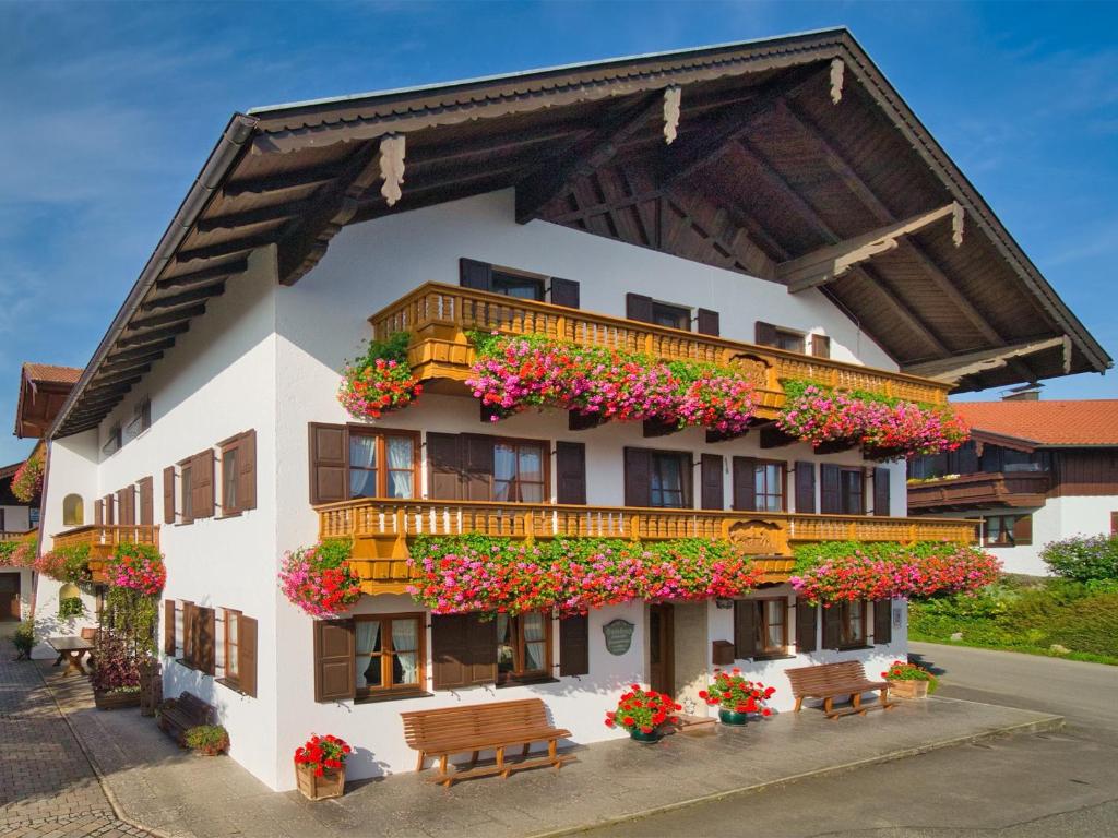 un edificio con balcones y flores. en Schererhof, en Rimsting
