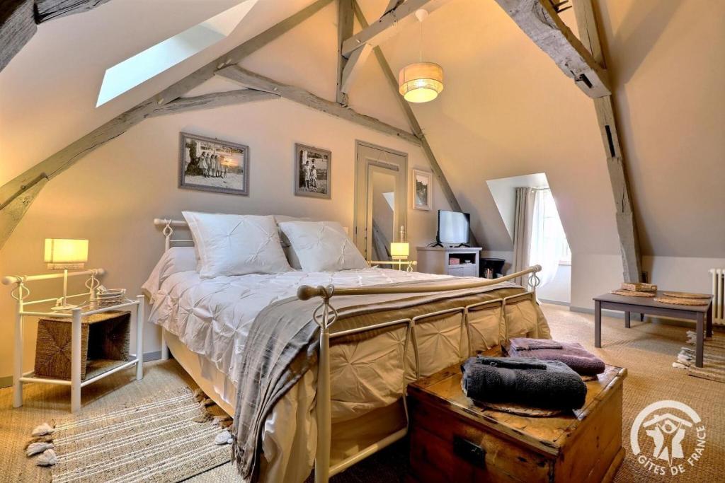 a bedroom with a bed in an attic at La gentilhommiere in La Bazouges-du-Désert