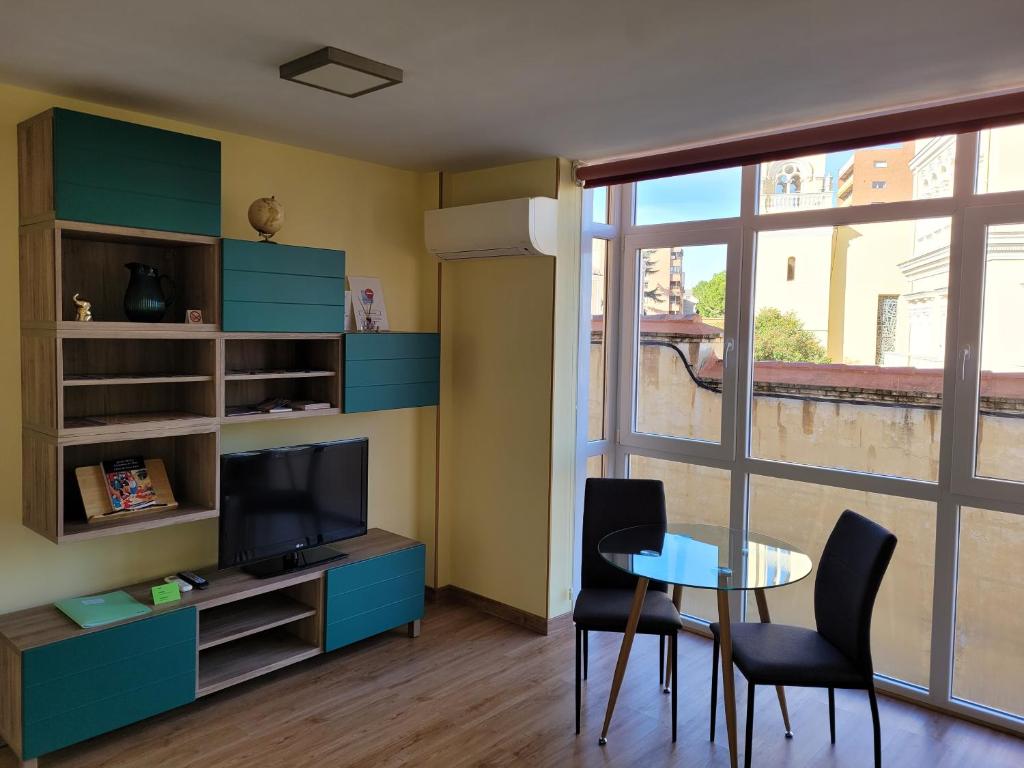 a living room with a table and a television at La Morada del Arcipreste in Guadalajara