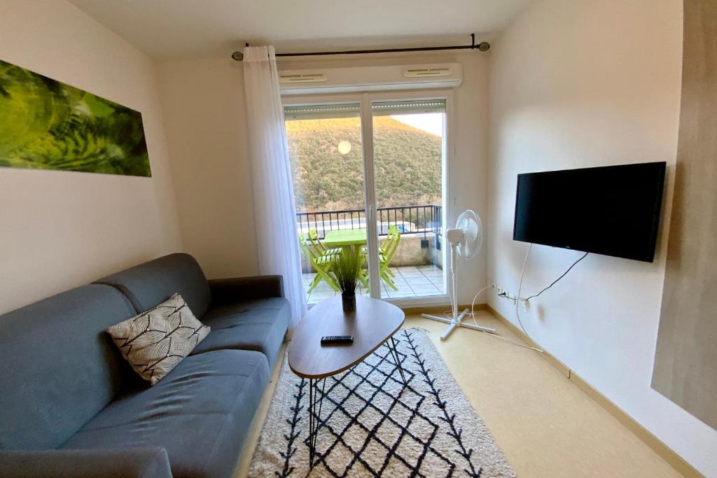 un salon avec un canapé bleu et une télévision dans l'établissement Les Naïades G36 - 2 bedrooms for 5 people !, à Avène