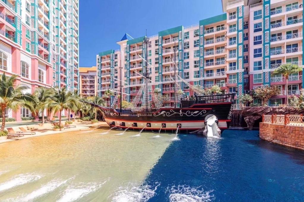芭達雅南區的住宿－Grand Caribbean Resort Pattaya，建筑物前水面上的一艘大船