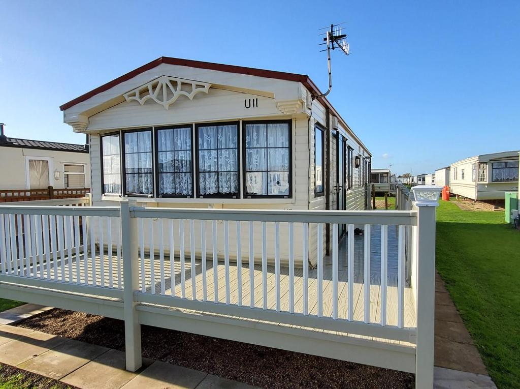 a small house with a white fence at Skegness Caravans in Skegness