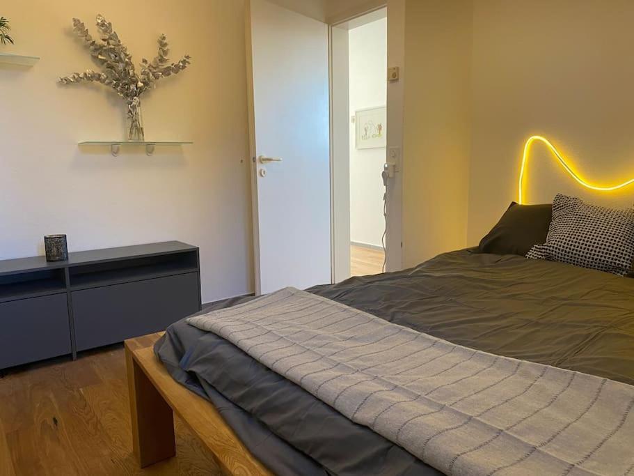 um quarto com uma cama com uma mesa e uma planta na parede em 2 1/2-Zi-Wohnung (Bijou im Stadtzentrum) em Murten