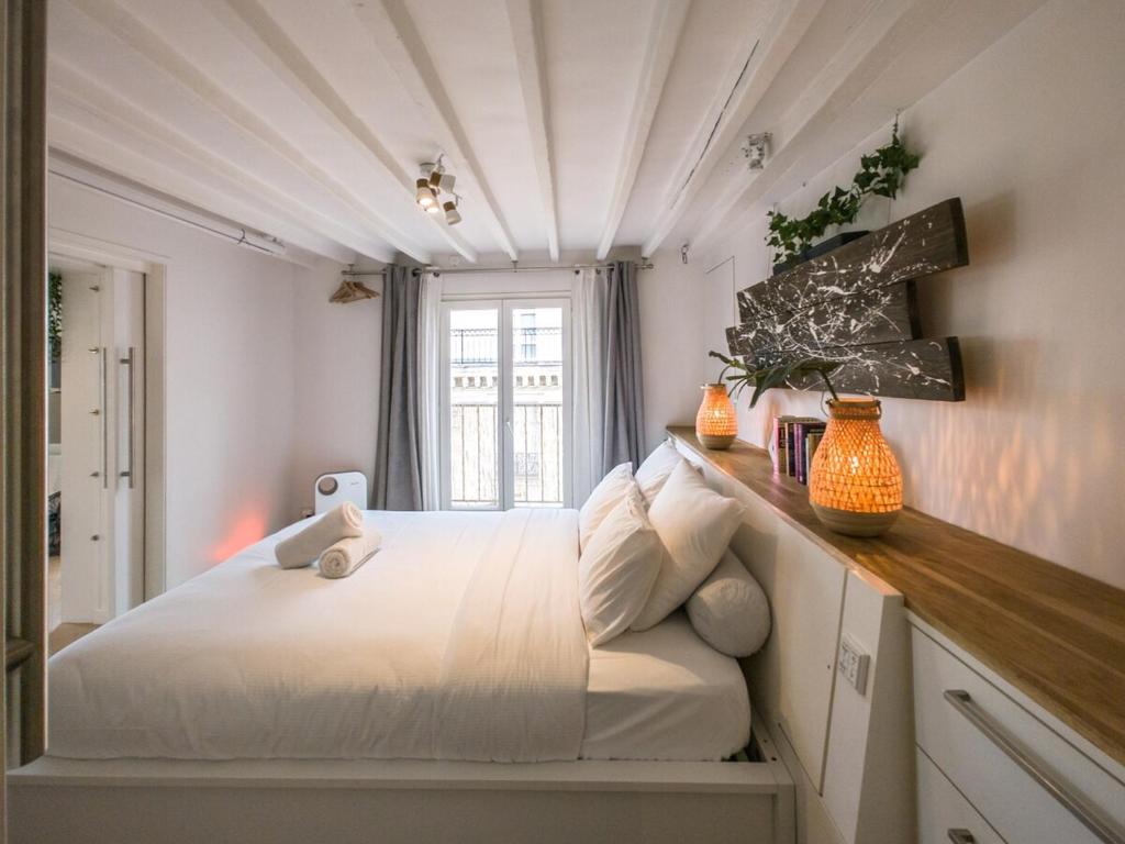 une chambre avec un grand lit blanc et une fenêtre dans l'établissement Saint-Germain-Des-Près Love Story, à Paris
