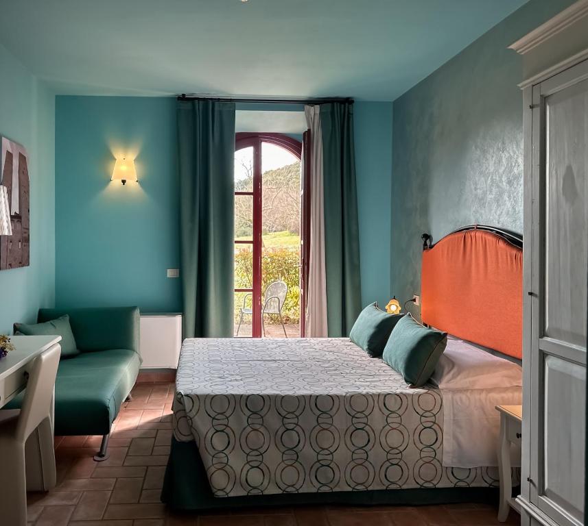 1 dormitorio con cama, sofá y ventana en Apartments in Villetta Terre Rosse, en San Gimignano