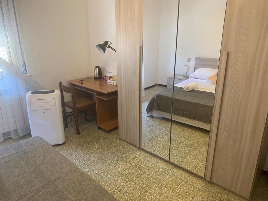 um quarto com uma secretária, uma cama e um espelho em Skyy guest house em Pisa