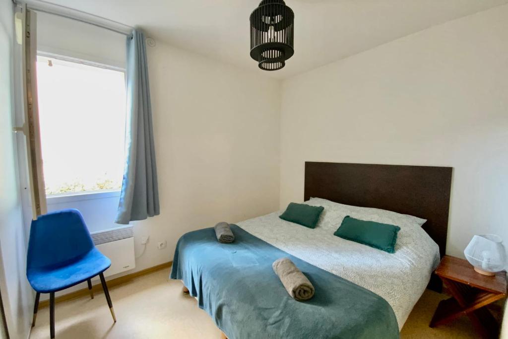 une chambre avec un lit et une chaise bleue dans l'établissement Les Naïades H40- 2 bedrooms for 6 people !, à Avène