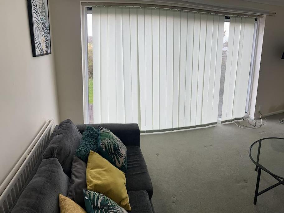 ein Wohnzimmer mit einem Sofa und einem großen Fenster in der Unterkunft 3 Bed House with free parking in Wolverhampton