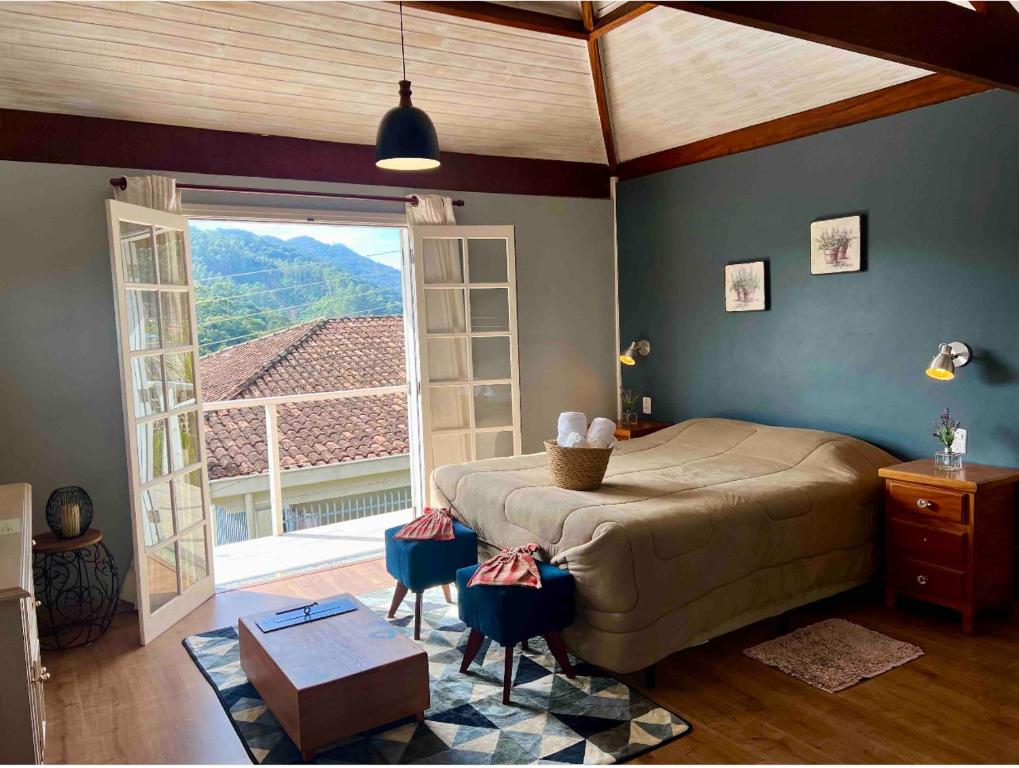 a bedroom with a large bed and a large window at Suite Lavanda in Santo Antônio do Pinhal