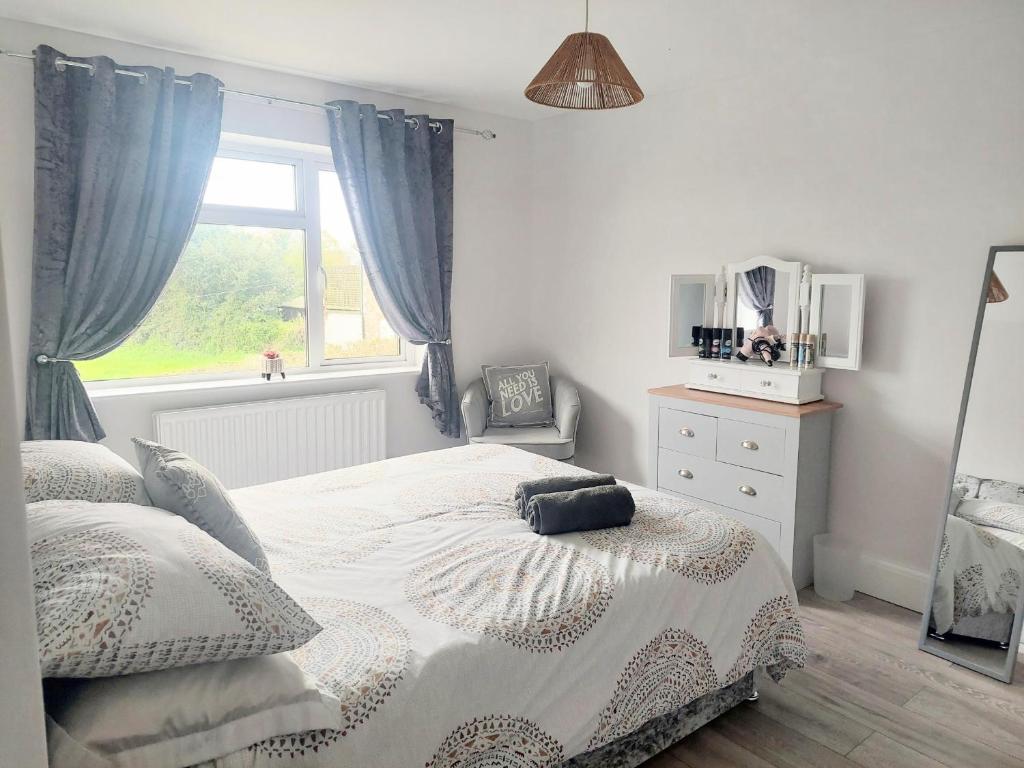 a white bedroom with a bed and a window at 'Serenity in Somerset' , Scenic Views across Dorset , Half a mile from Devon & Close to the Jurassic Coast without the Hustle & Bustle in Chardstock