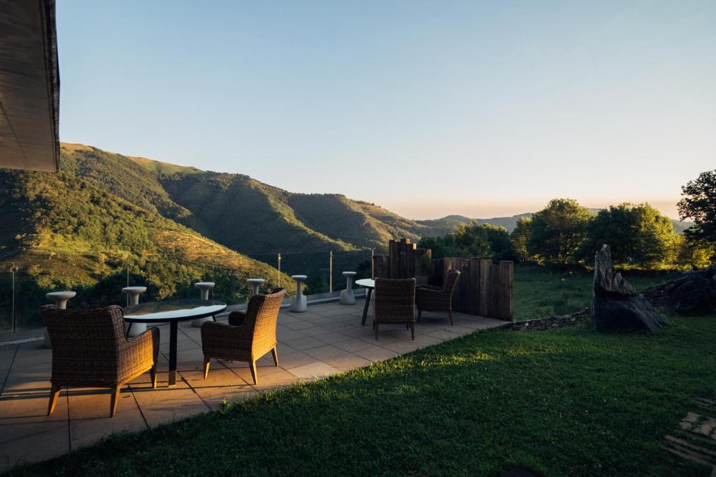 un patio con sillas y mesas con vistas a una colina en Arantza Hotela- Adults Only, en Arantza