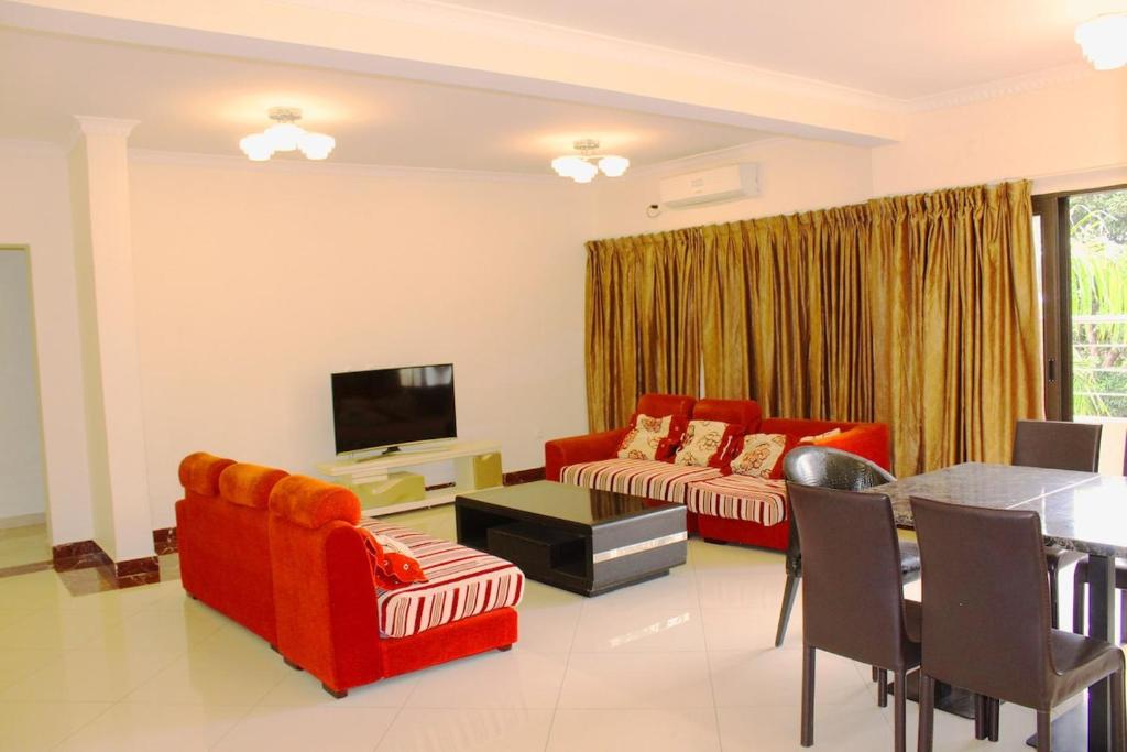 een woonkamer met een rode bank en een tafel bij Matola View Residence in Matola