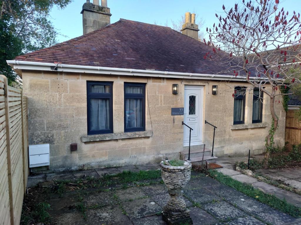 a small brick house with a white door at Newly renovated 2-bed bungalow in Bath