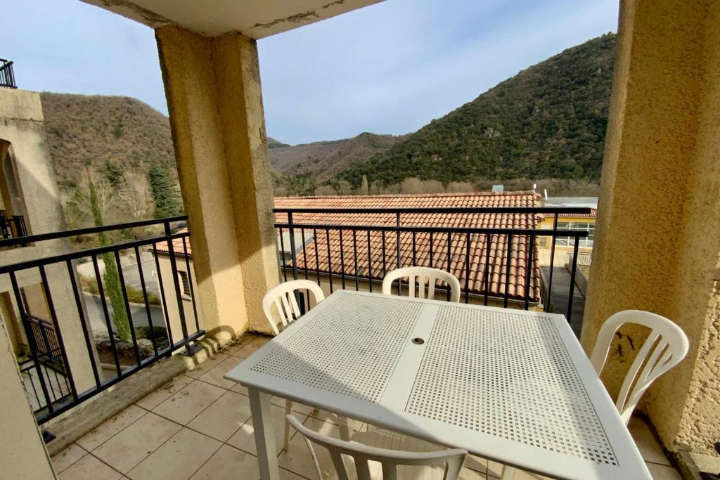 a white table and chairs on a balcony with mountains at Les Naïades I52 - 2 bedrooms for 5 people ! in Avène