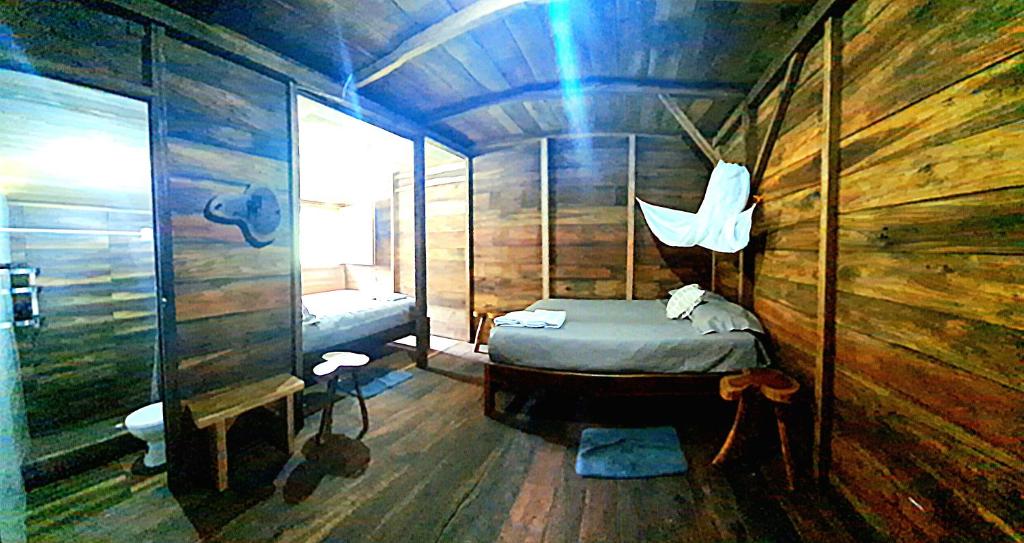 a bedroom with a bed in a wooden cabin at Rainforest Hut in Archidona