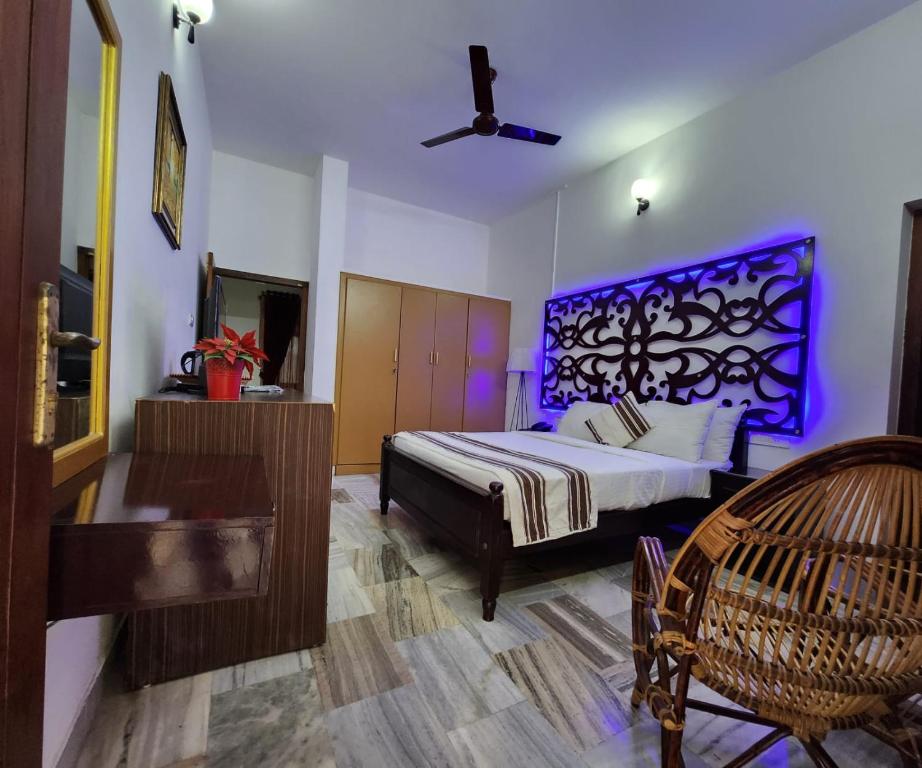 een slaapkamer met een bed met paarse verlichting bij Bharatham Heritage Inn in Kannur
