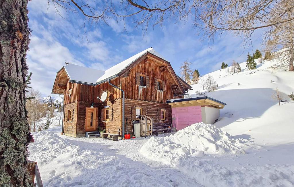 a wooden cabin in the snow with a pink door at 6 Bedroom Gorgeous Home In Lachtal - Schnberg in Hinteralm