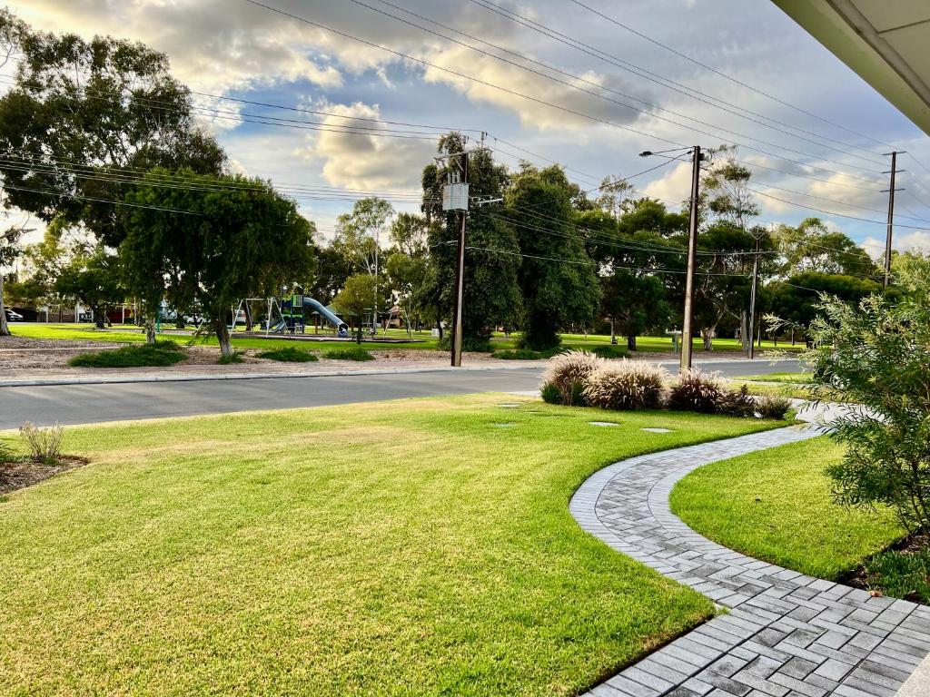 a walkway in a park next to a road at Parkview Cottage in Henley Beach South