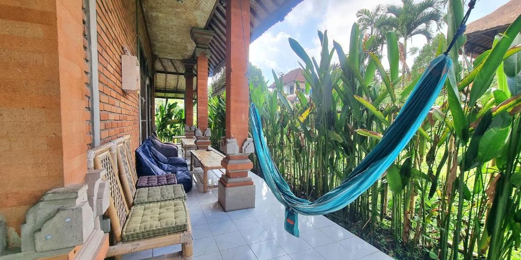 a porch with a hammock on a house at Keladi House Ubud in Ubud