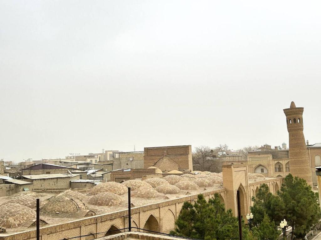 a view of a city with a clock tower and buildings at Rahmat guesthouse in Bukhara