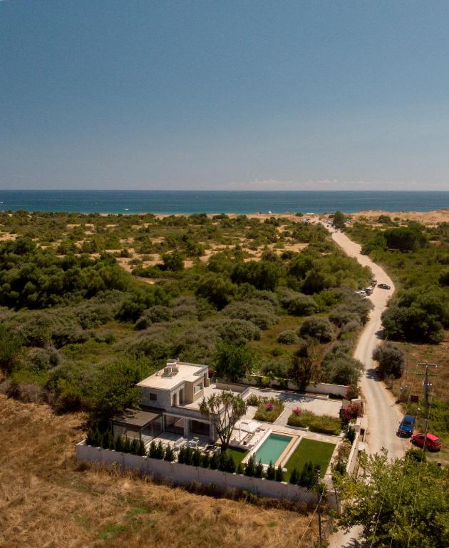 an aerial view of a house with the ocean in the background at Villa Flamingo - 4 bedrooms - Private Pool - Next to renowned Issos Beach & Lake Korission in Línia