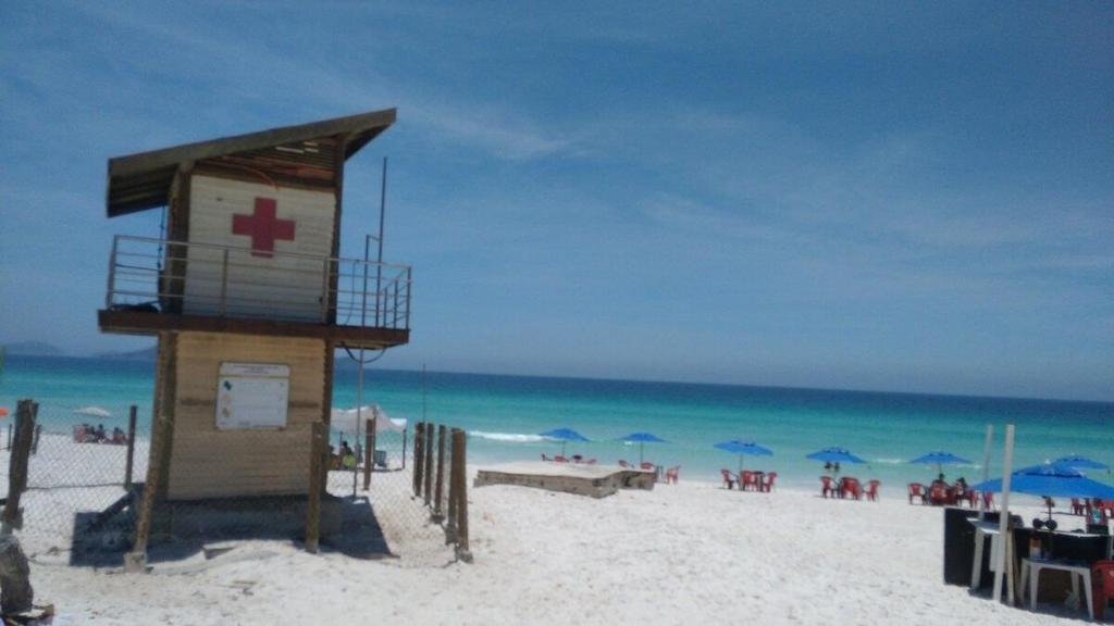 a lifeguard tower on a beach with chairs and umbrellas at EXCLUSIVE - AMPLO, FAMILIAR E PRÓXIMO DE TUDO in Cabo Frio