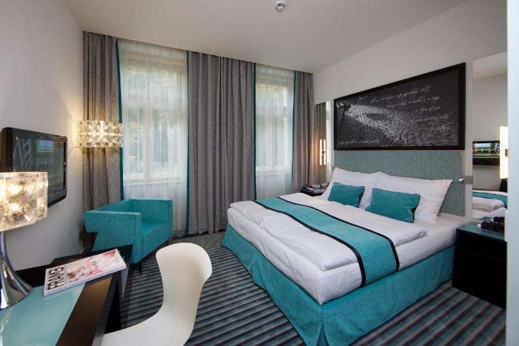 a hotel room with a large bed and a desk at Red & Blue Design Hotel Prague in Prague