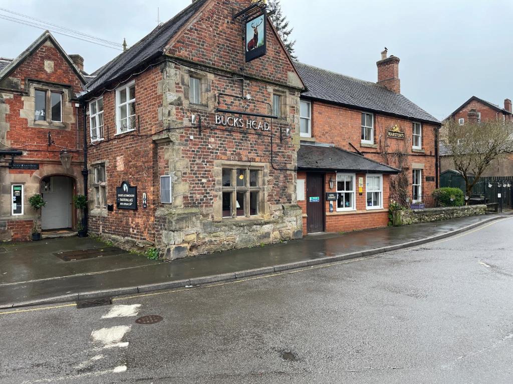 un viejo edificio de ladrillo al lado de una calle en The bucks head hotel, en Church Stretton