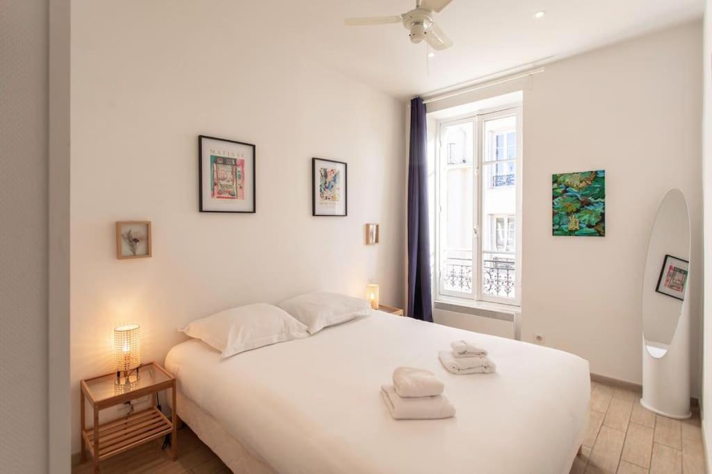 une chambre avec un grand lit blanc et une fenêtre dans l'établissement #21 2 Bdr balconies 10 mins walk to sea 5mins to tram, à Nice
