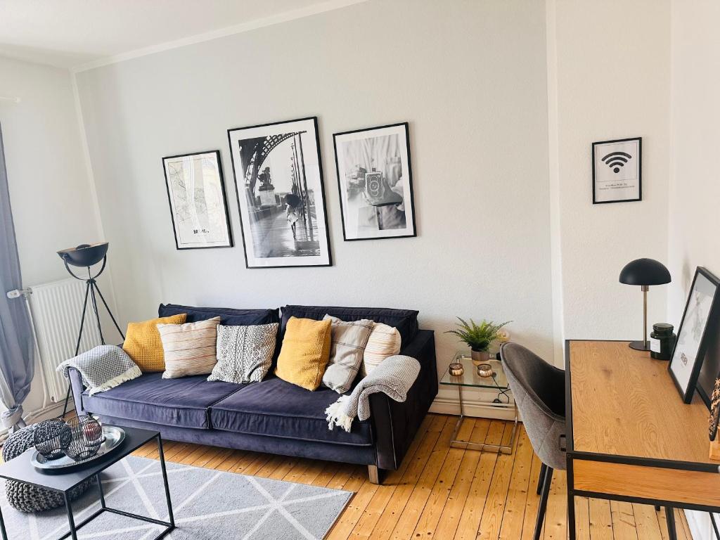 a living room with a blue couch with pillows at Schönes 2-Zimmer-Apartment in Bremen, Findorff in Bremen