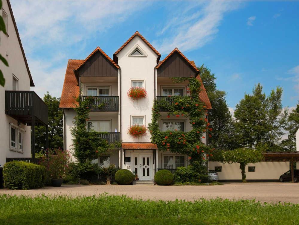 a large white building with two roofs at Kur & Golf Ferienwohnungen Wattenbach in Bad Windsheim