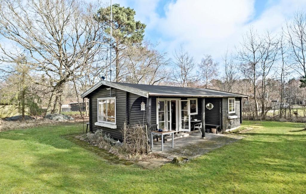 una pequeña cabaña negra en un campo de hierba en 2 Bedroom Lovely Home In Frederiksvrk, en Frederiksværk