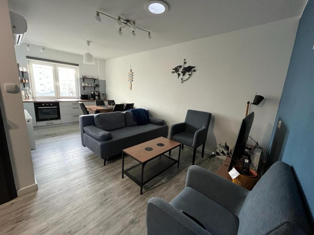 a living room with a couch and chairs and a table at Apartament Hugo in Świnoujście