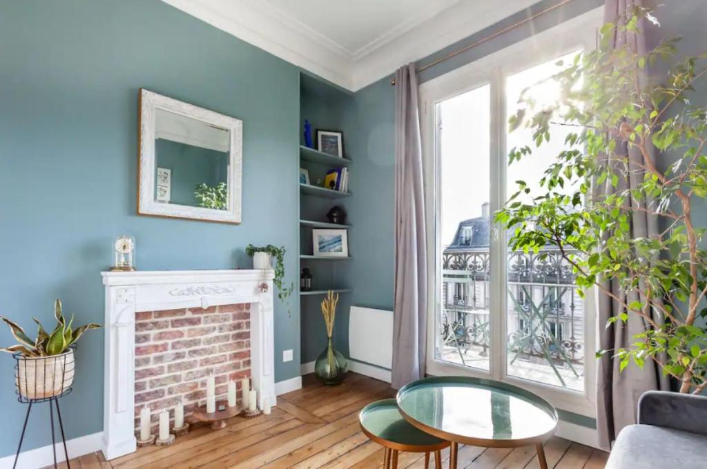 Elle comprend un salon doté de murs bleus et d'une cheminée. dans l'établissement Ruby Magenta, à Paris