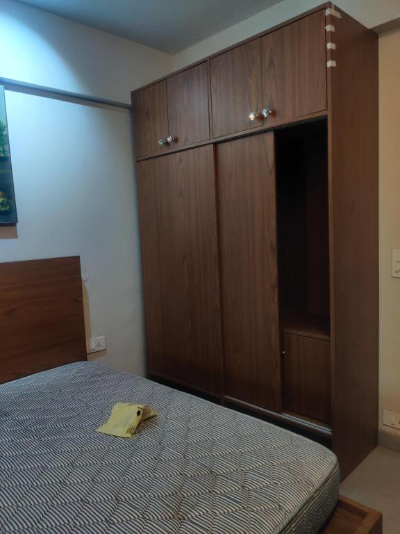 a bedroom with a bed and wooden cabinets at Essel tower ews falt 8 Floor in Gurgaon