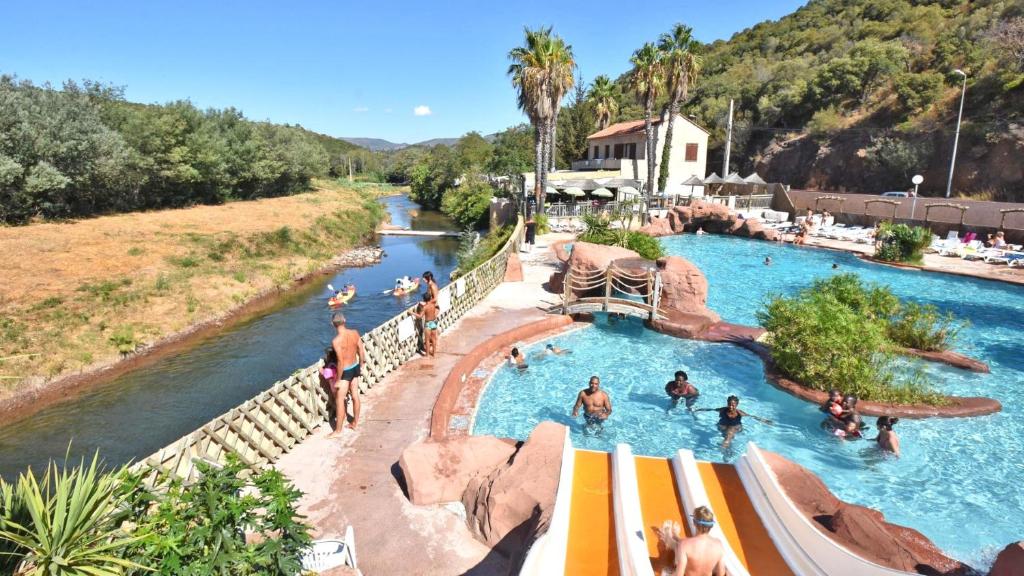 - une piscine dans un complexe avec des personnes dans l'eau dans l'établissement Camping Agay, à Agay