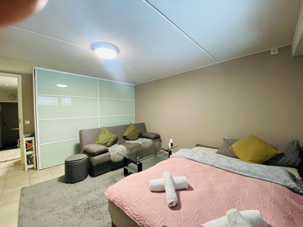- une chambre avec un lit et un canapé dans l'établissement Welcoming shared room with free parking and sauna, à Vantaa