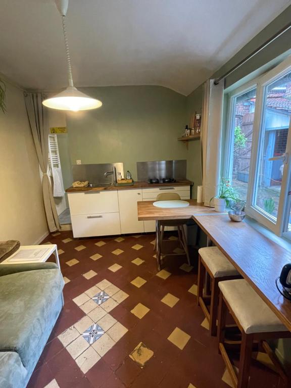 a living room with a table and a kitchen at Le clos de Marissel in Beauvais