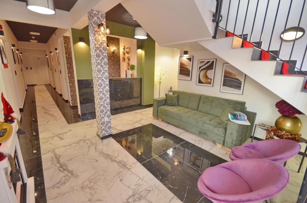 sala de estar con sofá verde y taburetes púrpura en Residence Spa Apartments DUB en Kotor