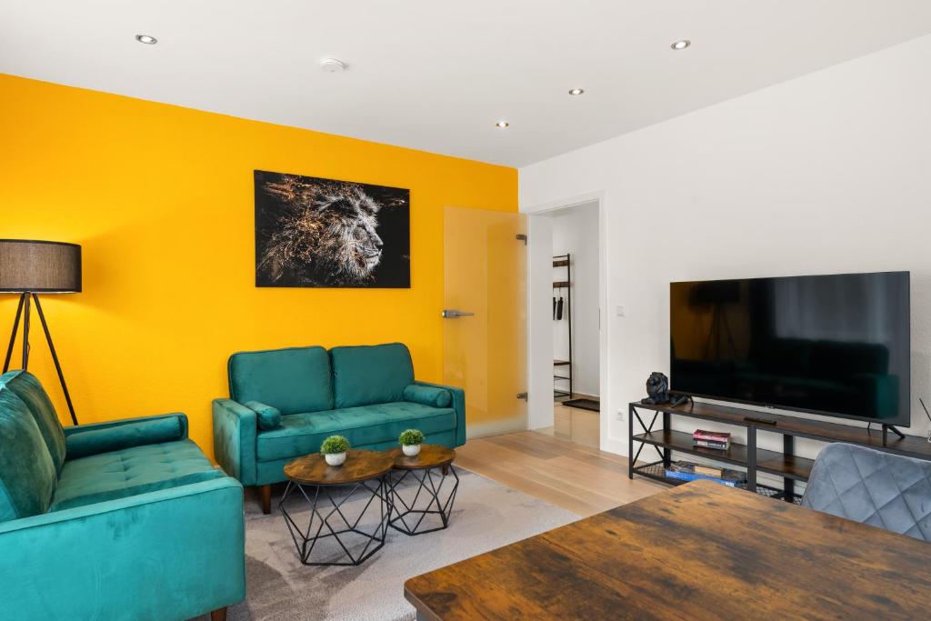 un soggiorno con 2 divani blu e una TV di FREE LIVING - Jungle Design Apartments, Zentrum, Parkplatz, Küche, Wlan a Wolfsburg
