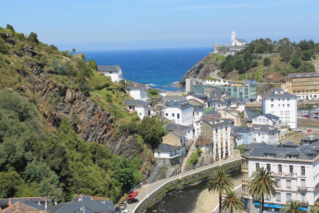 a town on a hill next to the ocean at Apartamentos turísticos Vistademar in Luarca