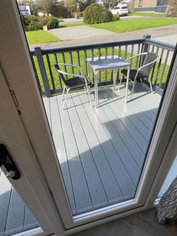 a balcony with a table and chairs on it at Modern homely Chalet in Tuxford in Askham