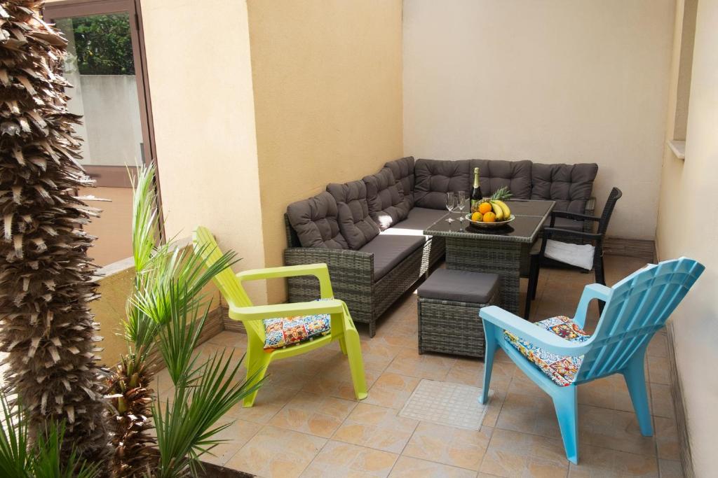 eine Terrasse mit Stühlen, einem Sofa und einem Tisch in der Unterkunft Appartamenti Leone in San Vito lo Capo