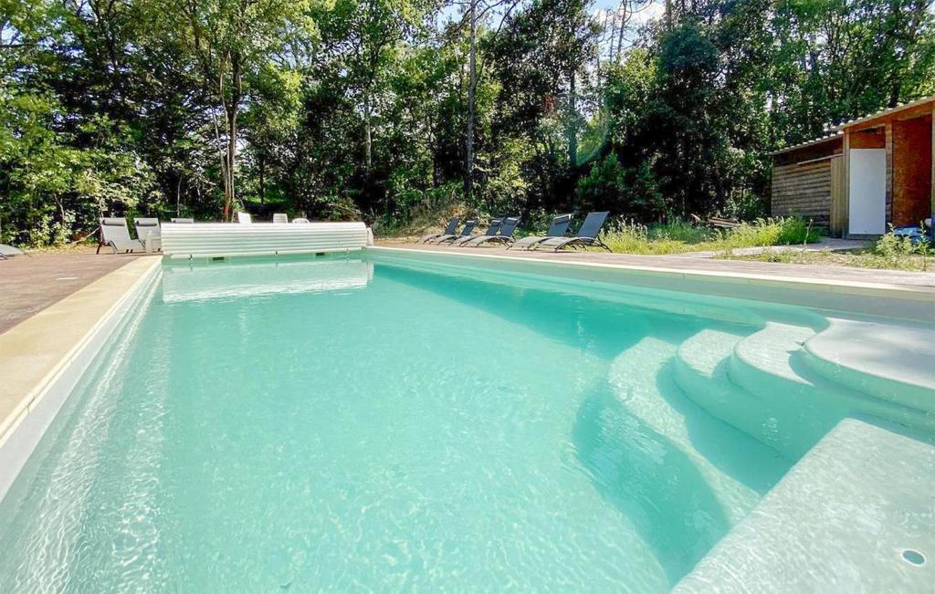 Una piscina de agua azul con un banco. en Cozy Home In Pennautier With Wifi, en Pennautier