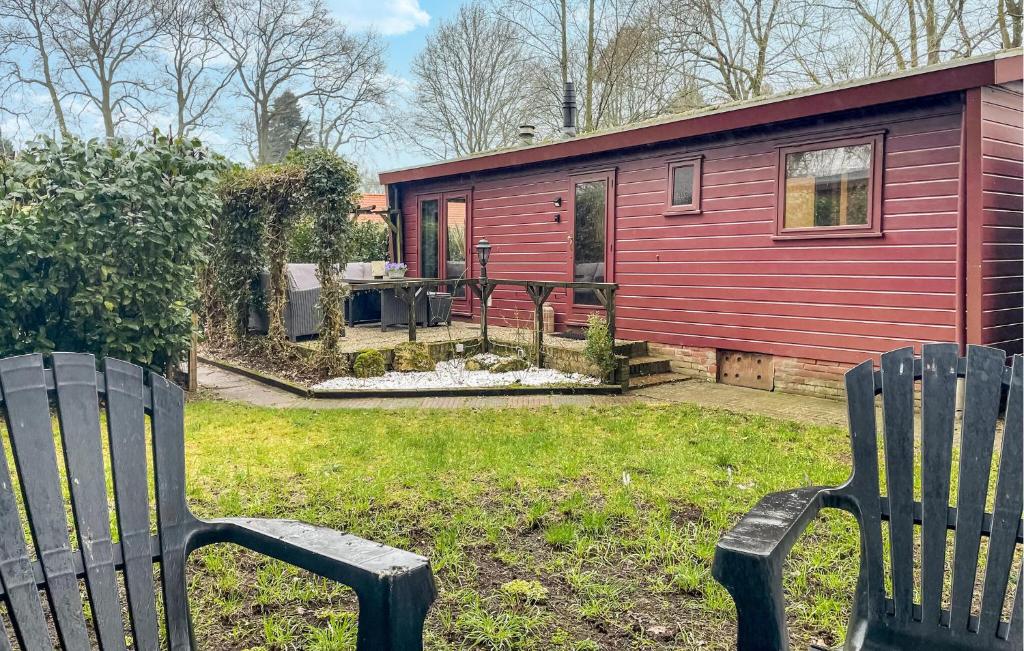 une cabine rouge avec deux bancs devant elle dans l'établissement 1 Bedroom Cozy stacaravan In Putten, à Putten